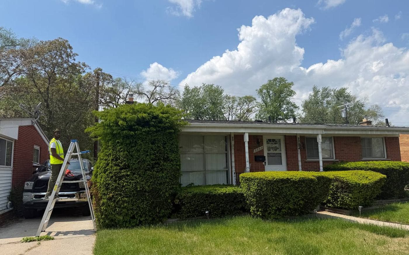 Woolfman Lawn Services crew trimming on a Detroit property